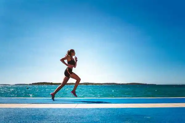 Woman running showing strong leg muscle Bushey